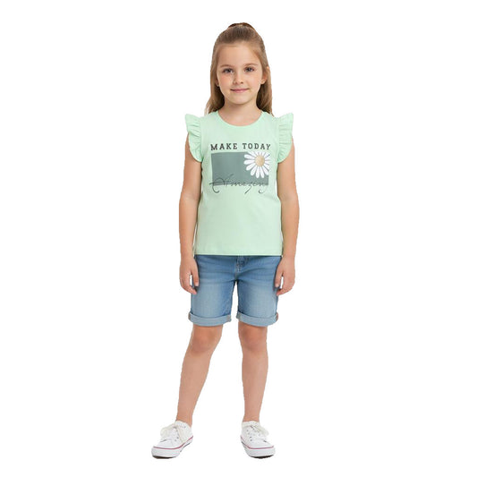 Young girl wearing a light green t-shirt with a graphic and blue shorts on a white background
