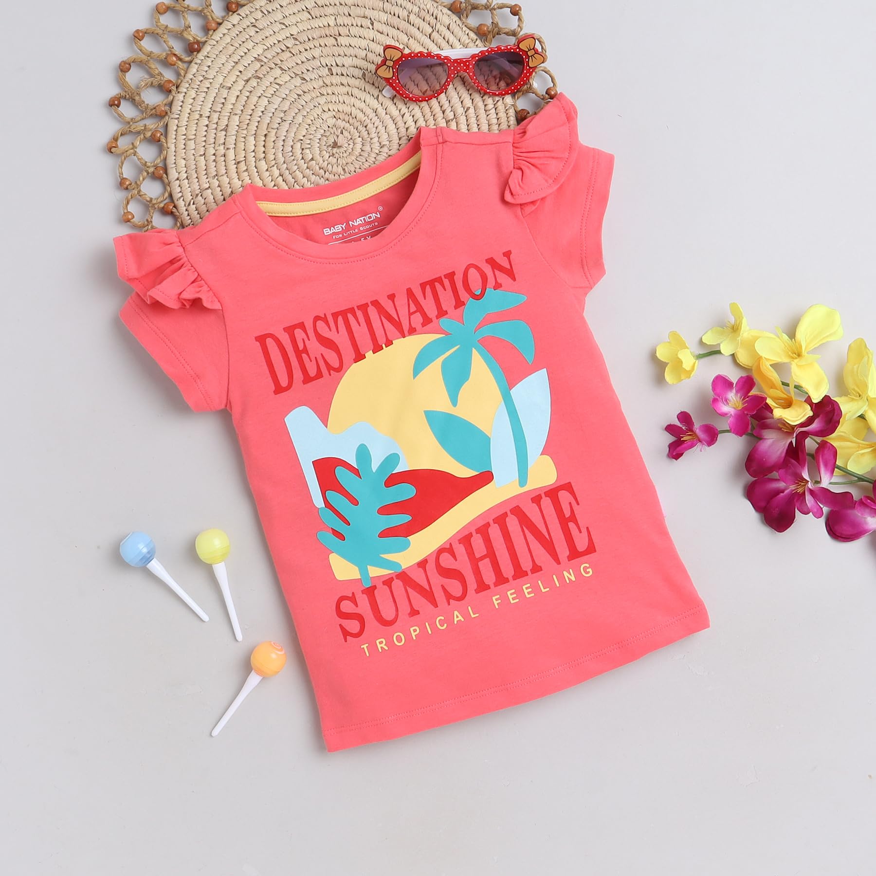 Coral pink children's t-shirt with 'Destination Sunshine' print on a light gray background