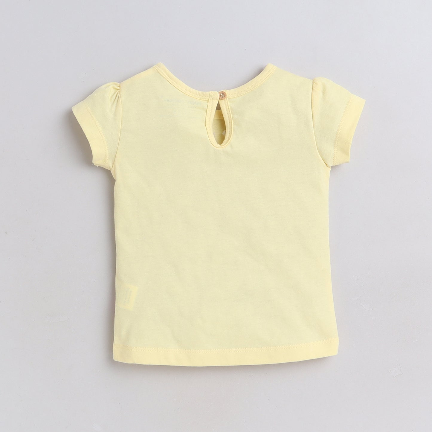 Yellow short-sleeve top on a light gray background