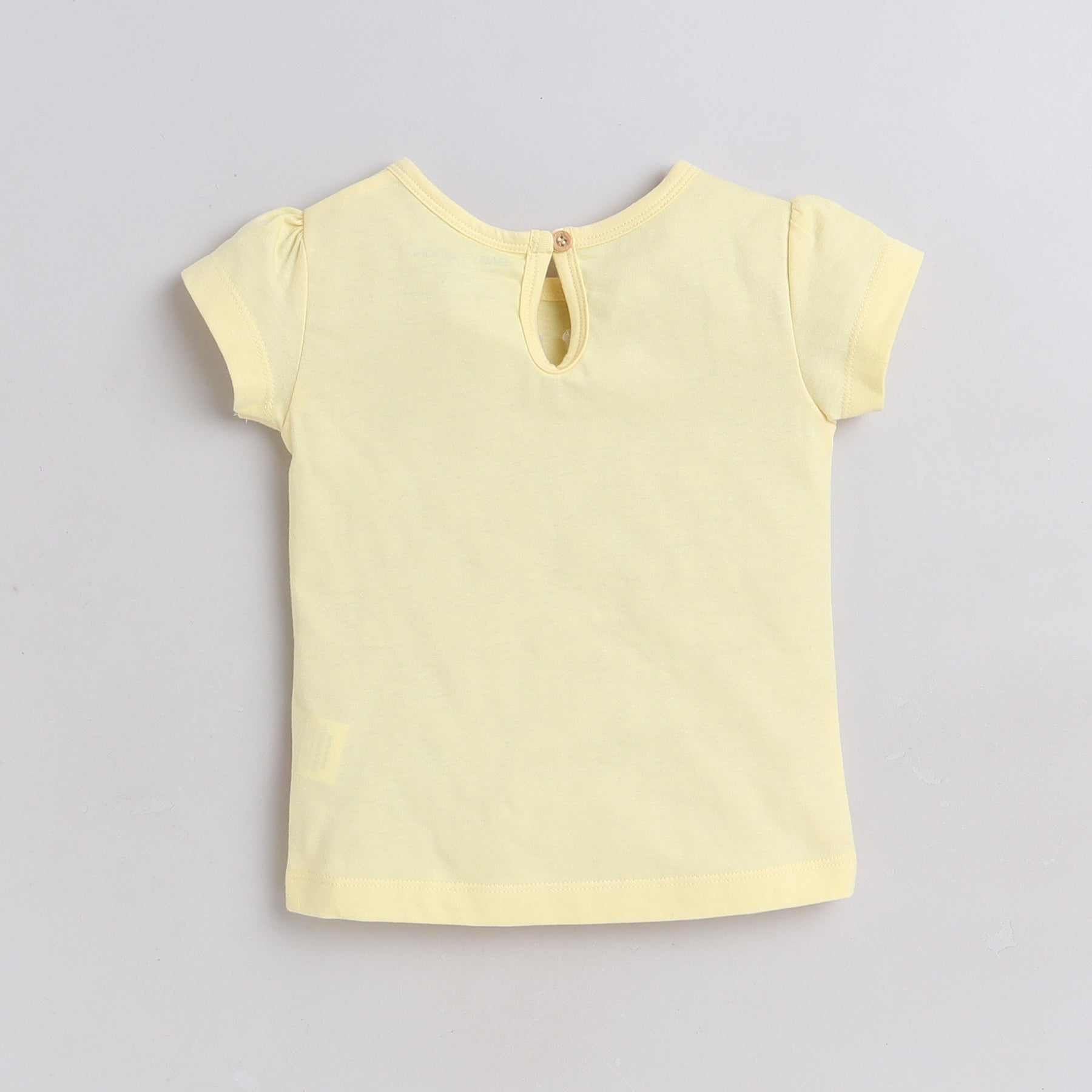Yellow short-sleeve top on a light gray background