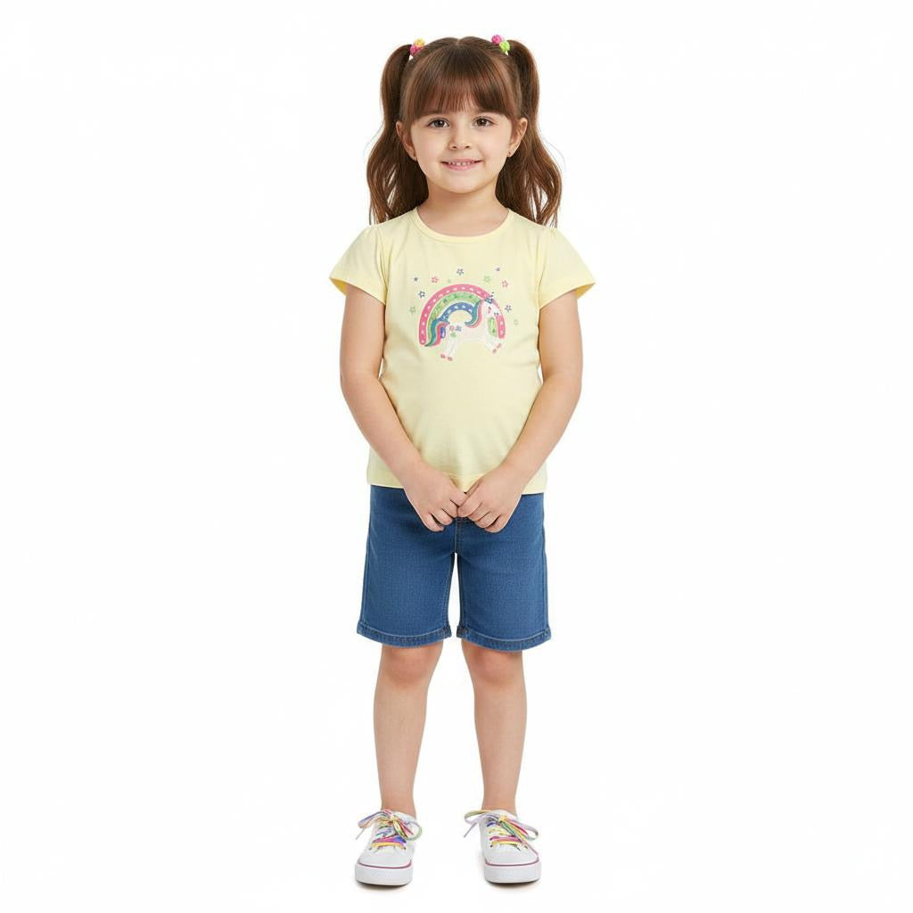 Young girl wearing a yellow t-shirt with a rainbow design and blue shorts on a white background