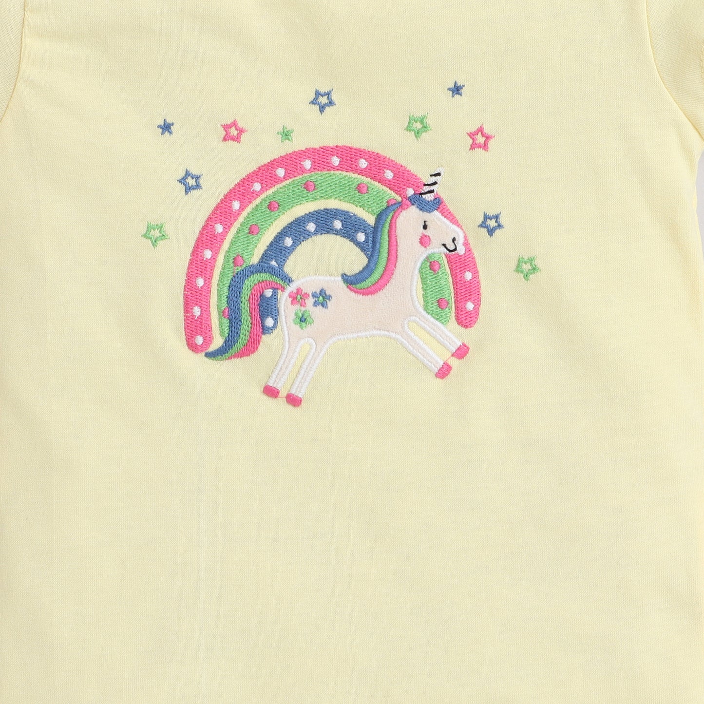 Embroidered unicorn design on a light yellow fabric background