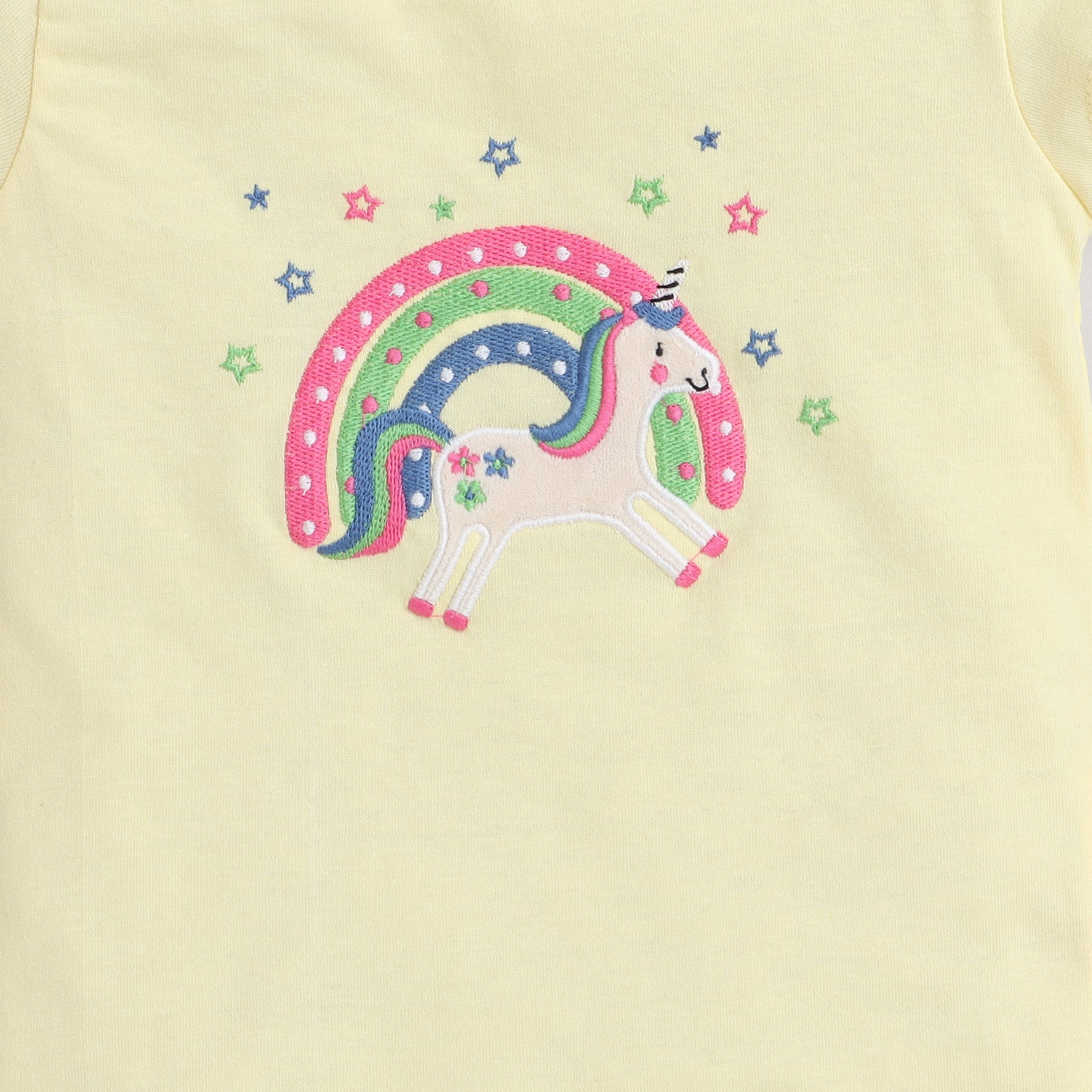 Embroidered unicorn design on a light yellow fabric background